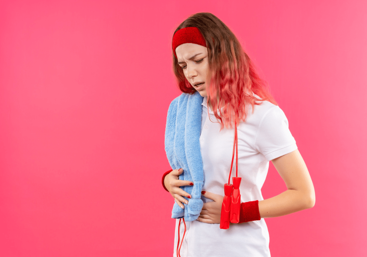 Girl with red hair, headband, and whistle, holding a blue towel on a pink background.