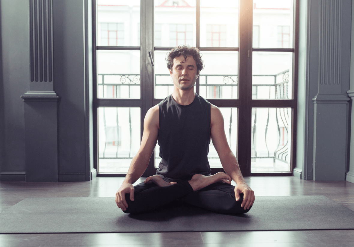 person meditating or doing yoga min